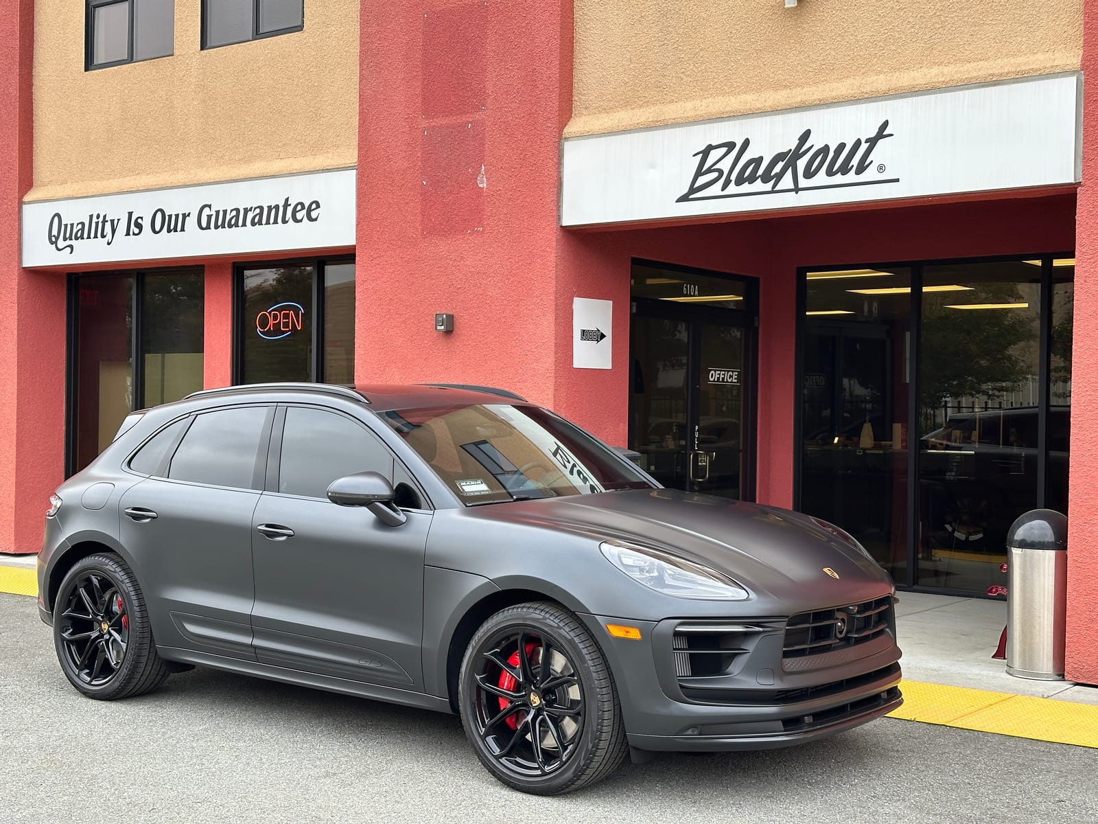 Porsche Macan GTS with corrected paint at Blackout Window Tinting storefront